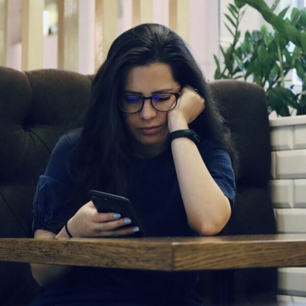 Sad girl looking at her phone