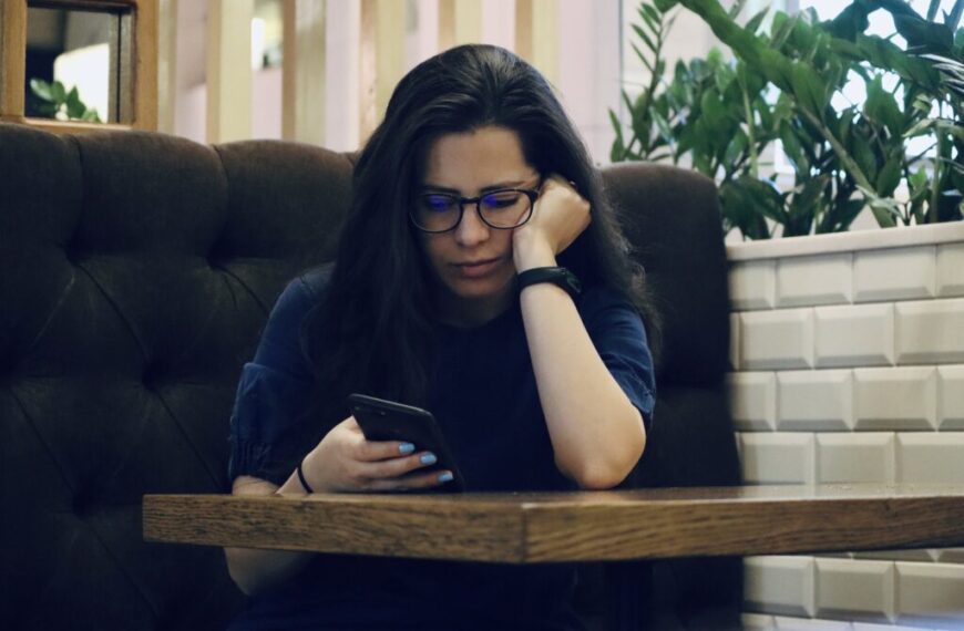 Sad girl looking at her phone